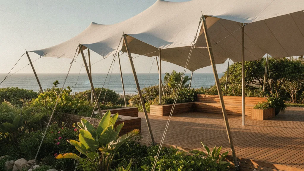 Waterproof white stretch tent tensioned over a green coastal garden and deck in East London